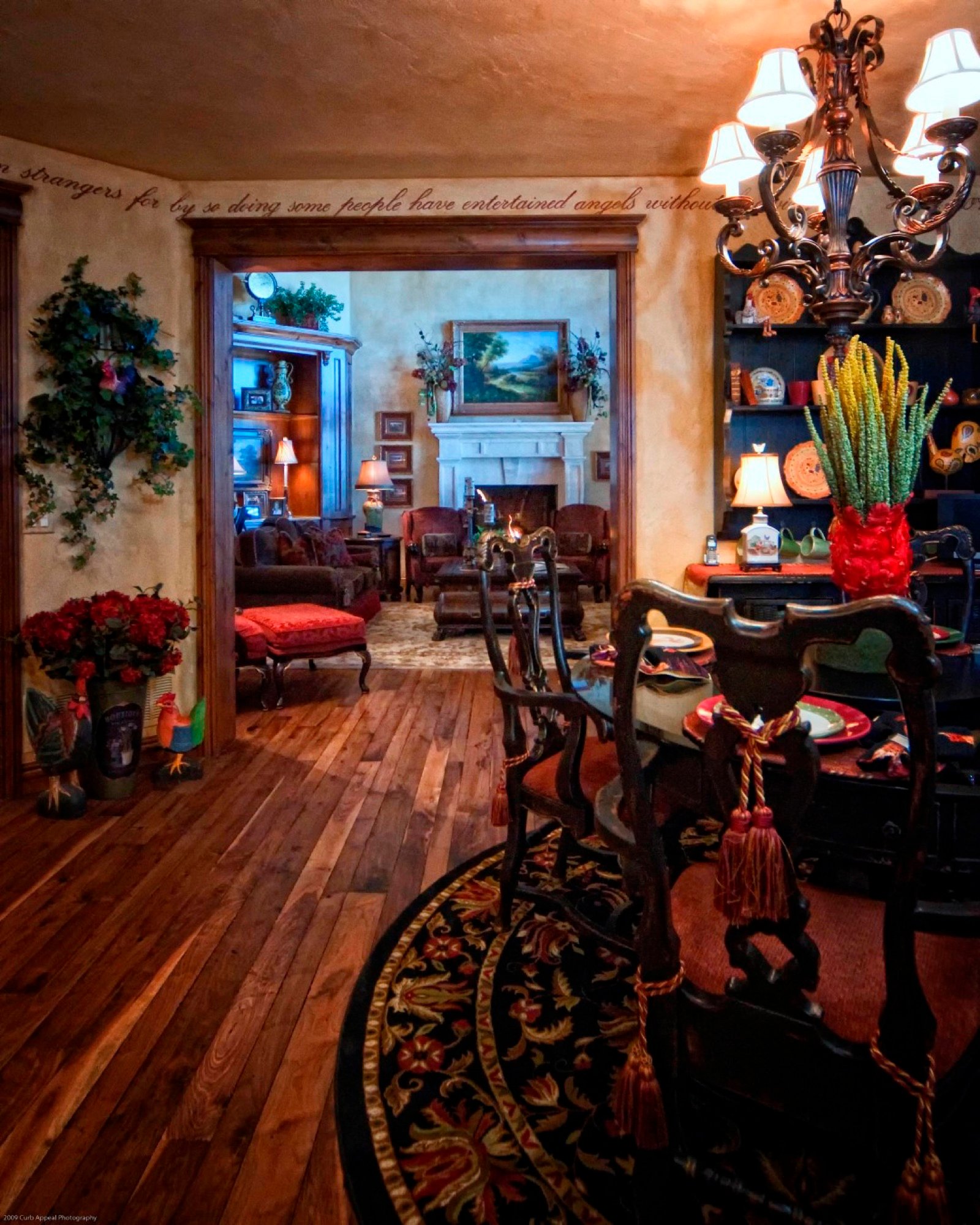 Classic dining room with iron chandelier and rich wood floors, designed by Carla's A Classic Design